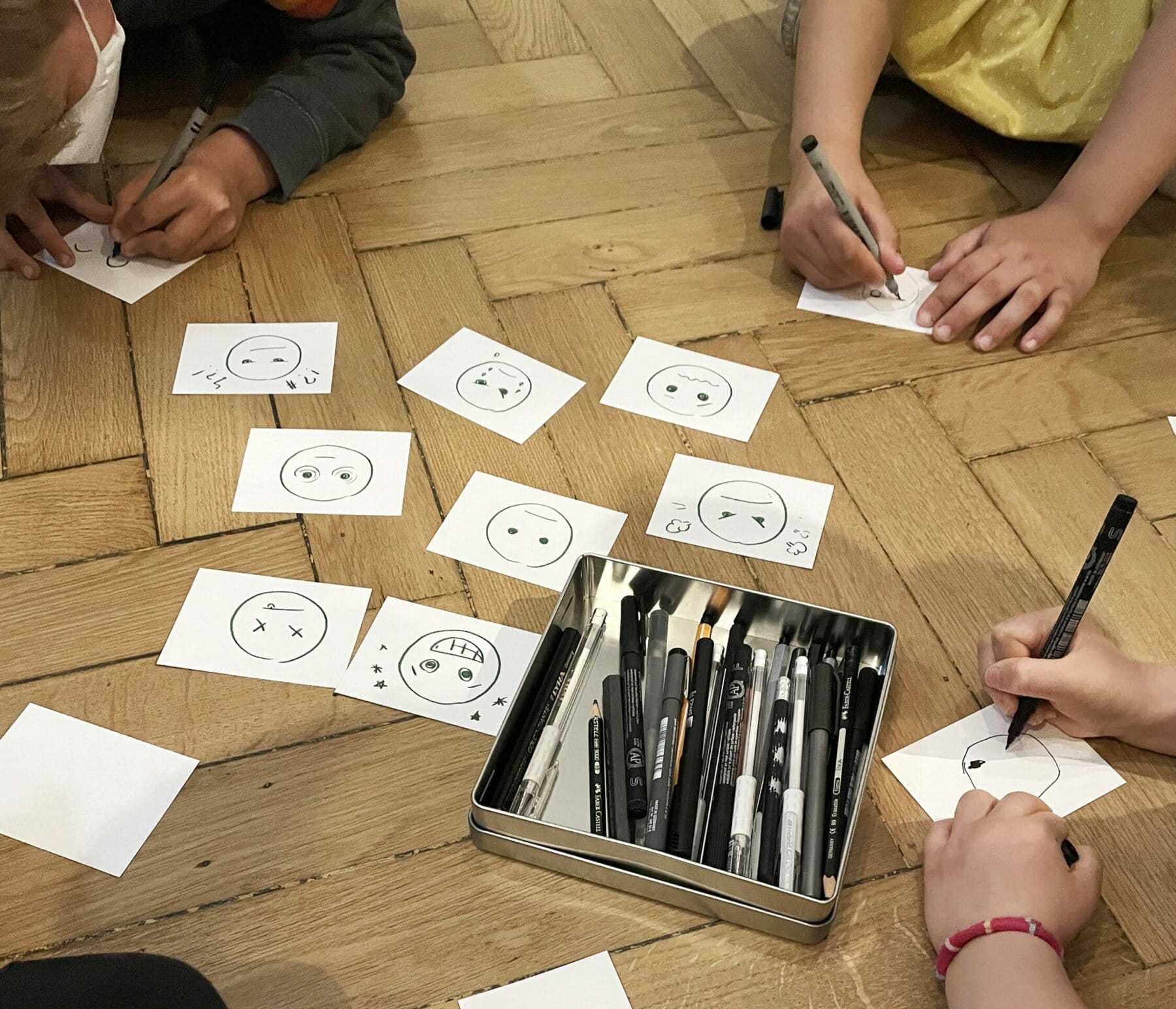 Kinder sitzen im Kreis und zeichnen.