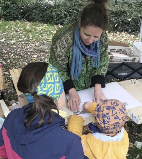 Ich stehe draußen. Mir gegenüber sitzt eine Mutter mit ihrem Sohn und gemeinsam basteln wir an einem Kaleidoskop.